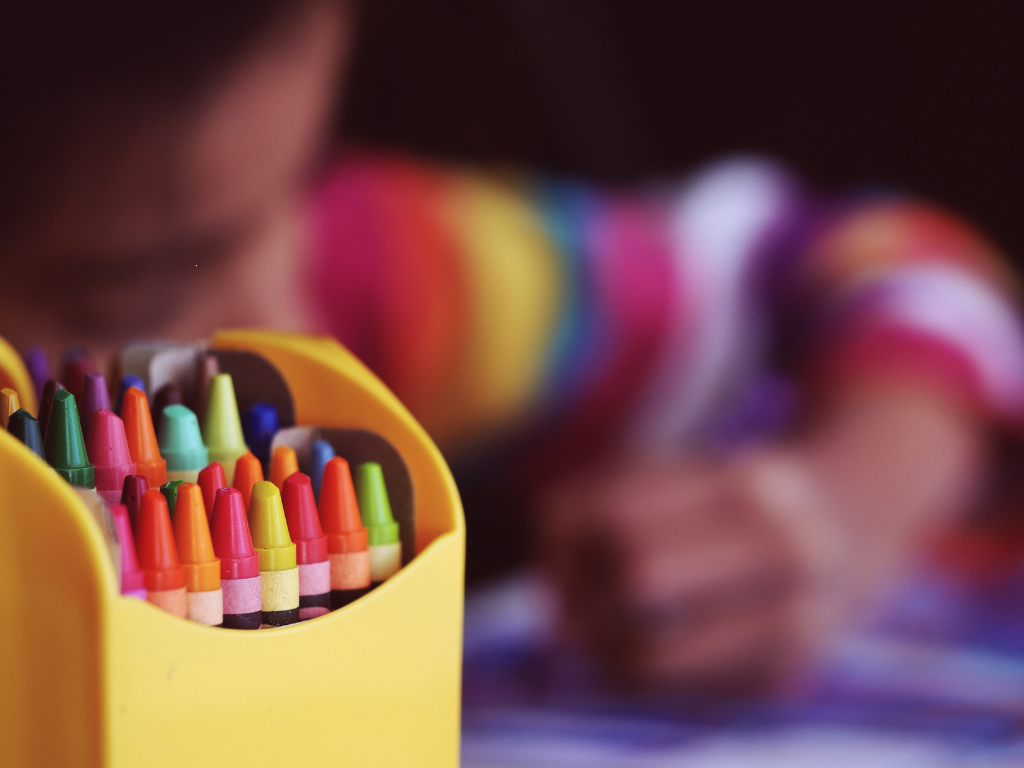A young child and drawing crayons