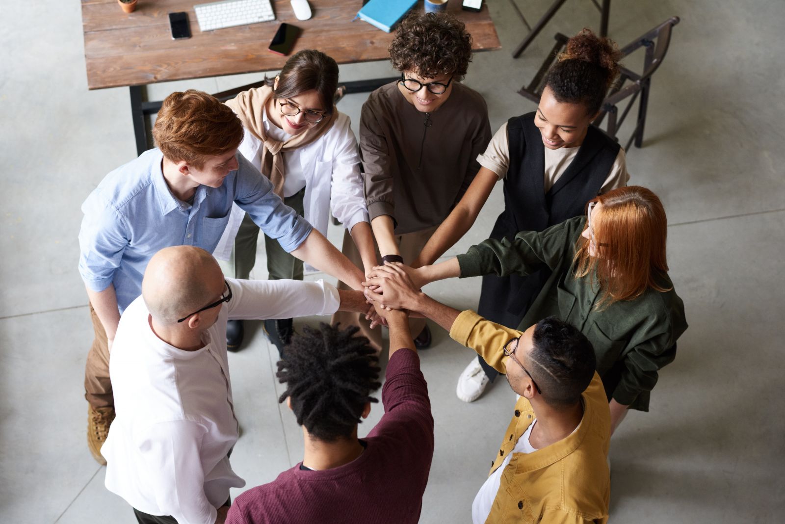 People in a circle with their hands in the middle